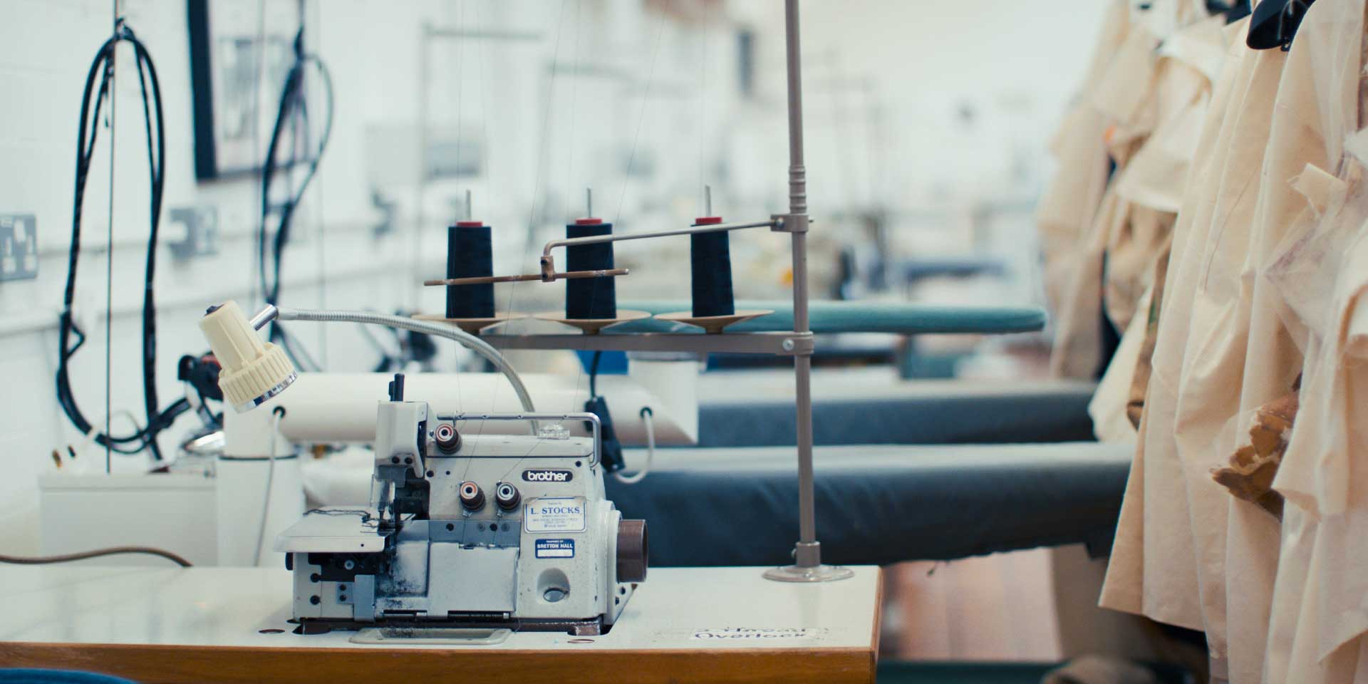A studio space equipped with dress forms, sewing workstations, and fabric supplies for fashion and textile design.