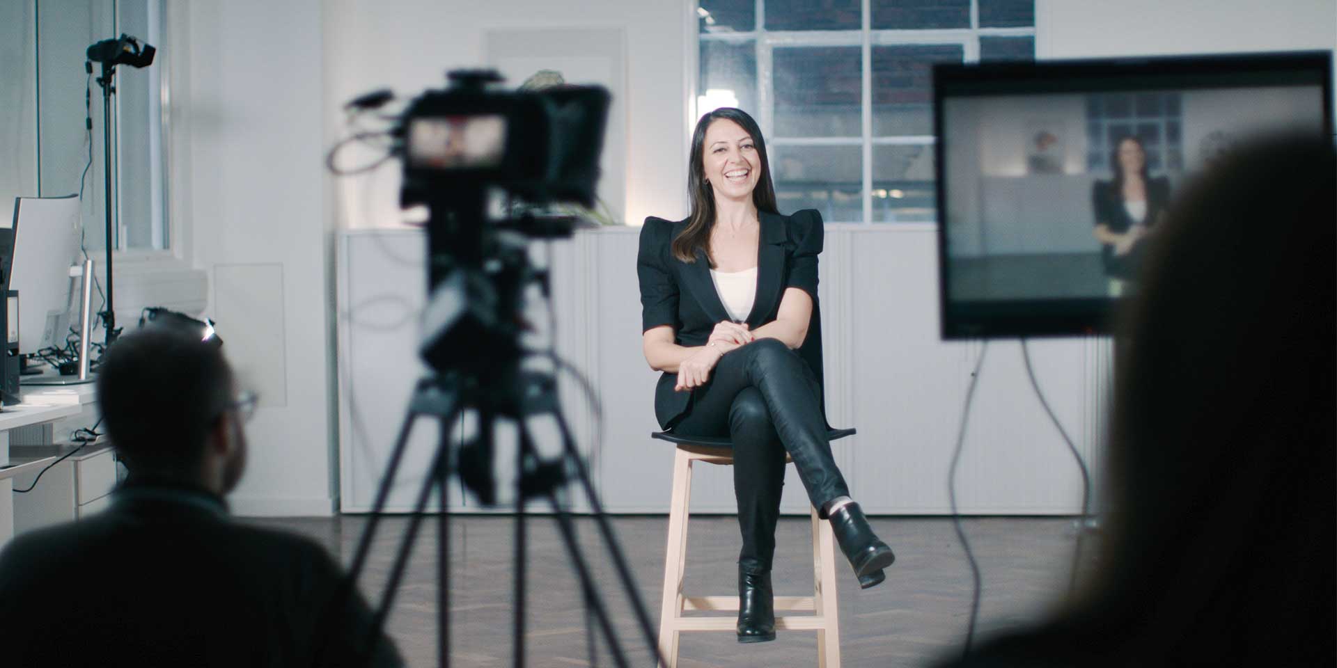 A photography and filming studio setup featuring professional lighting rigs, cameras, and backdrop stands.