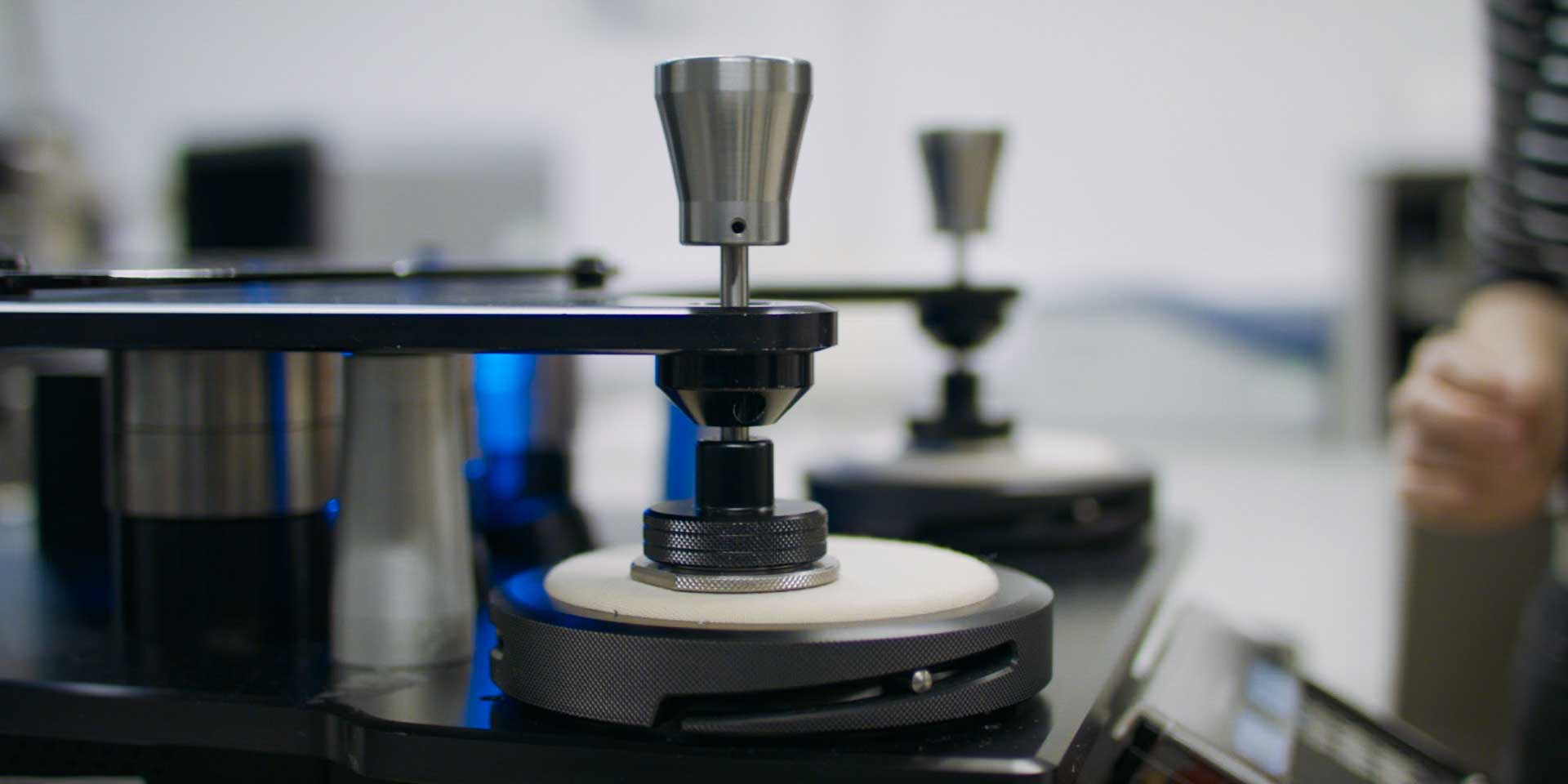 A Martindale abrasion test apparatus used in textile testing and colour chemistry laboratories to evaluate fabric durability.